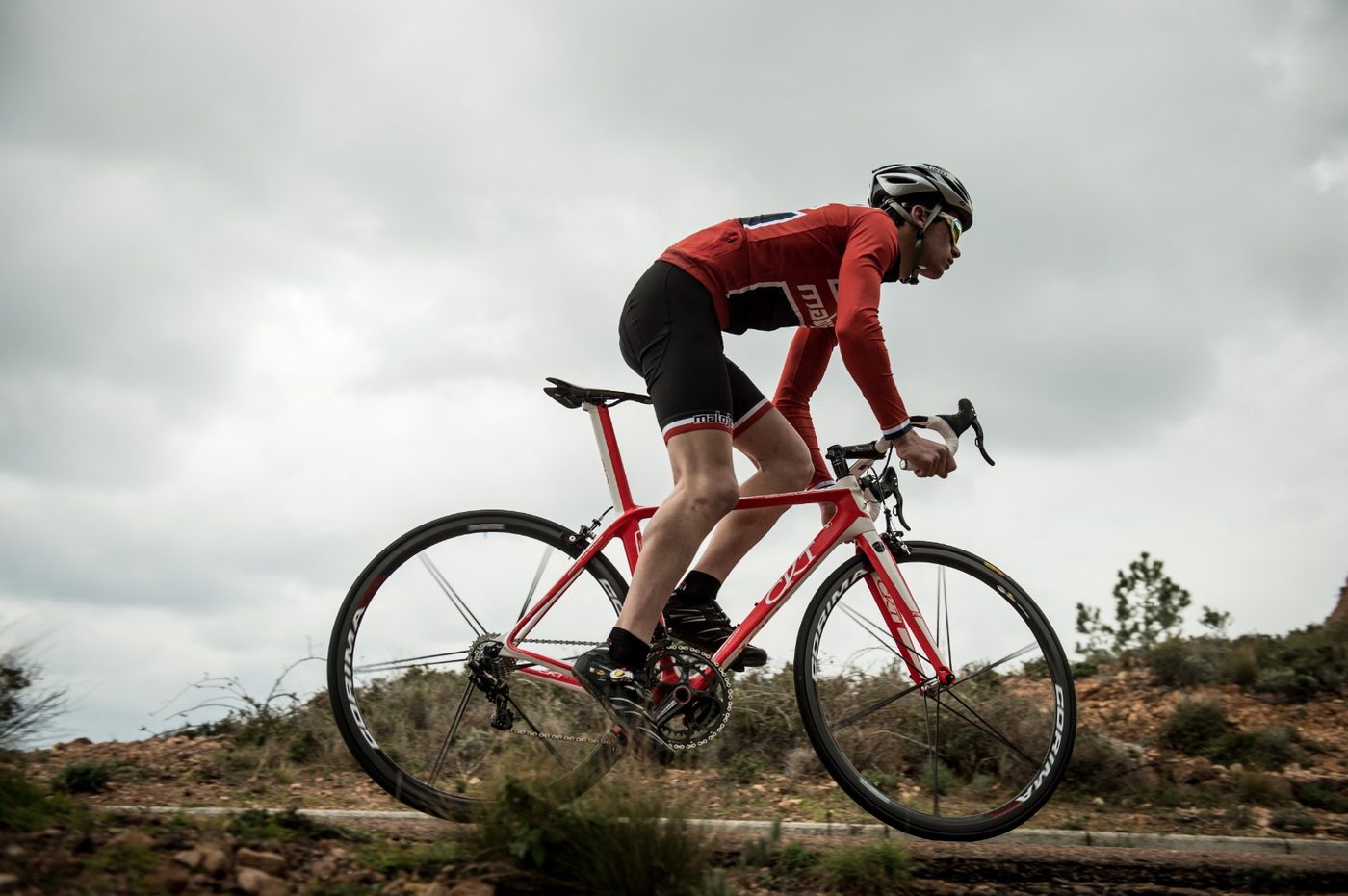 Rider on a red and white CKT carbon road bike